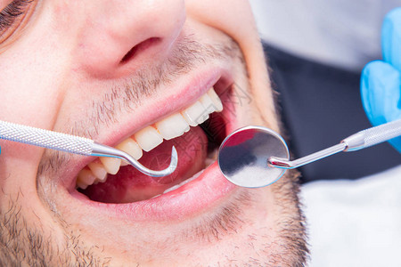 患者口腔中牙医工具的特写图片