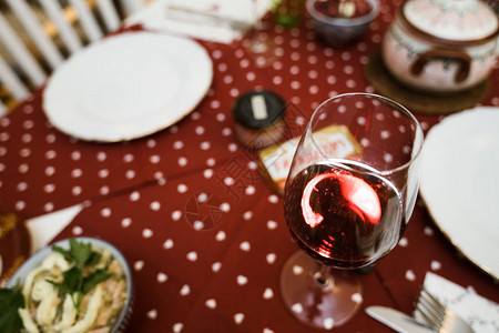 透明玻璃和红葡萄酒在节庆桌布上准备迎接圣诞节图片