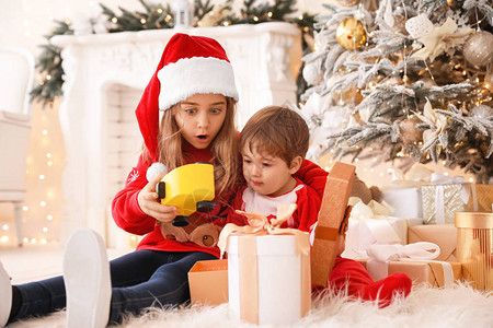 小孩子在家打开圣诞礼物图片