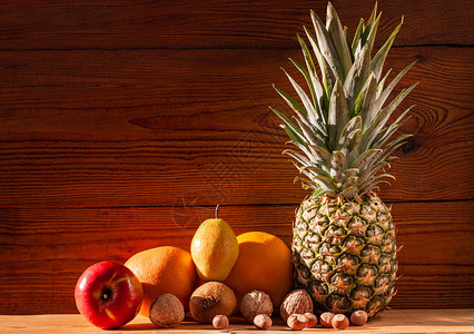 热带水果和坚果素食菠萝葡萄柚橙子梨核桃木背景健康食品成分极简风格健康的脂肪膳食图片