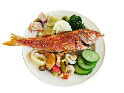 在白底盘上隔离的碗盘上的煮鱼和海鲜贝类图片
