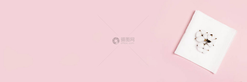 粉红色背景的纸巾和棉花概念是100种精细柔软的天然产品平坦的躺着图片