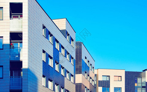 万物物联在住宅楼外部的公寓在欧洲的蓝色现代房子的住房结构夏季在市区出租房屋用于商业物投资的墙壁背景