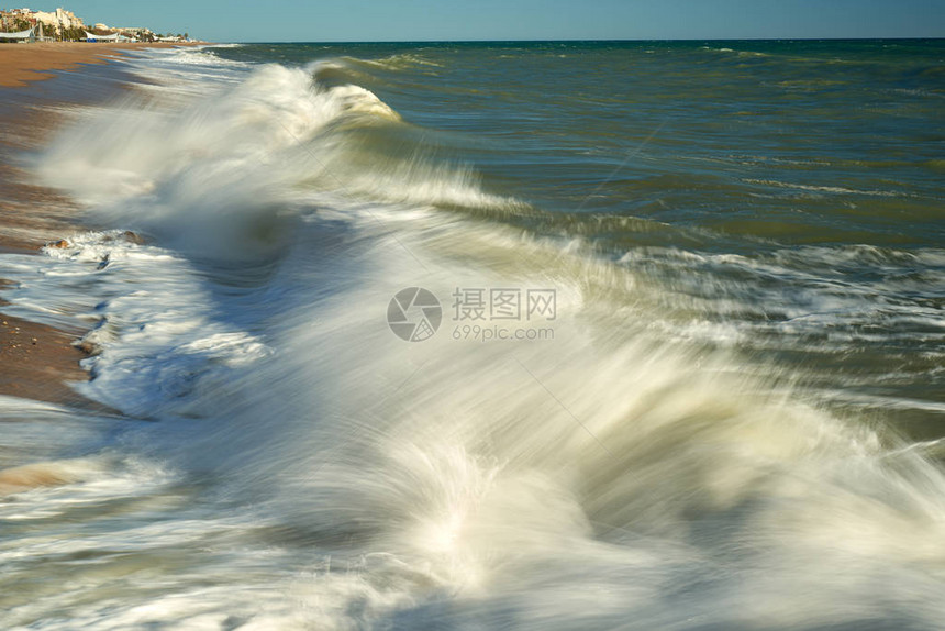 海浪拍打在石滩上形成浪花图片