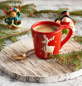 红瓷杯加黑咖啡靠近绿芽和圣诞玩图片