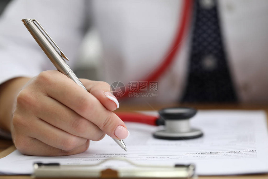 女医生手持银笔在病史中书写的特写镜头医务人员在脖子和制服上戴着红色听诊图片