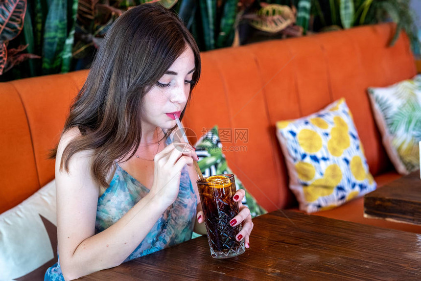 咖啡厅的年轻女孩饮用图片