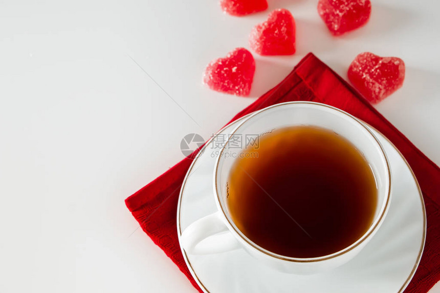 一杯白色背景的茶和一颗心形的红色果酱心形杯子里的烟概念图片