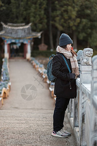 在玉龙雪山背景的黑龙潭旅游的年轻女游客图片