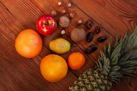 热带水果和坚果纯素饮食平板菠萝葡萄柚橙子梨核桃木背景健康食品配料极简风格健康脂肪膳食图片