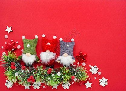 圣诞作文红色背景上的云杉树枝侏儒和圣诞装饰品平躺顶视图片