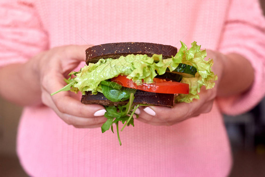 女手握健康三明治粉红毛衣黄瓜沙拉图片