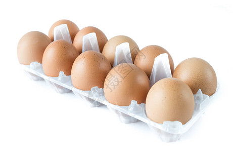 10个有机棕色蛋在塑料鸡蛋盒上孤图片