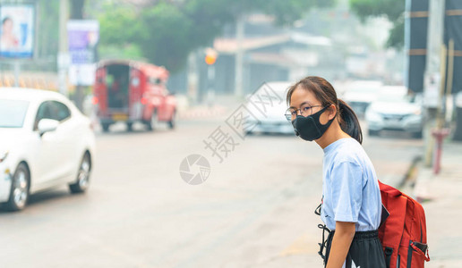 戴黑鼻子N95布防尘的小姑娘pm25在交通拥堵的城图片