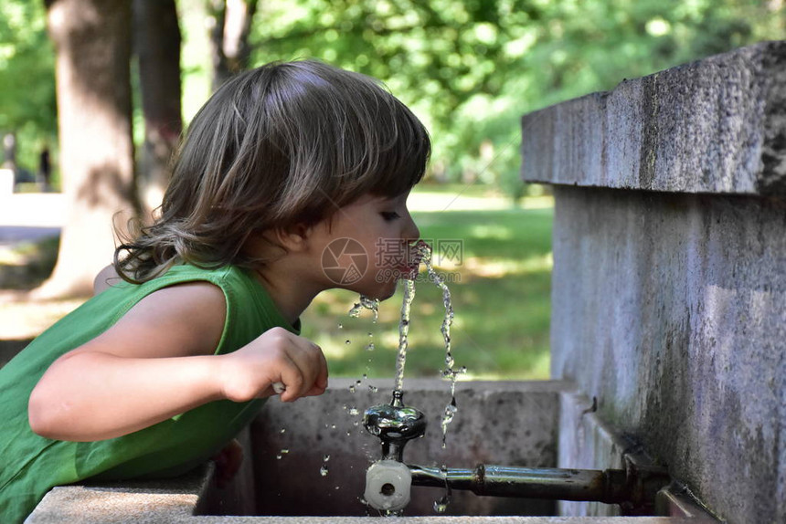 孩子从喷泉里喝水图片