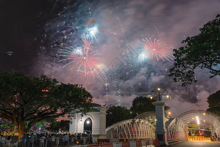 美丽的烟花汇演与拥挤的人们在新加坡观看新年前夜庆祝活动的剪影多背景图片