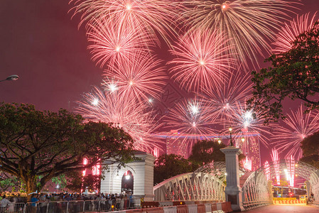 美丽的烟花汇演与拥挤的人们在新加坡观看新年前夜庆祝活动的剪影多背景图片