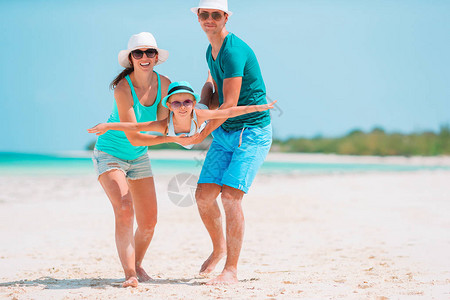 3个在海滩上快乐的一家人图片