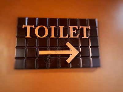 厕所标志的图像带箭头的棕色背景图片