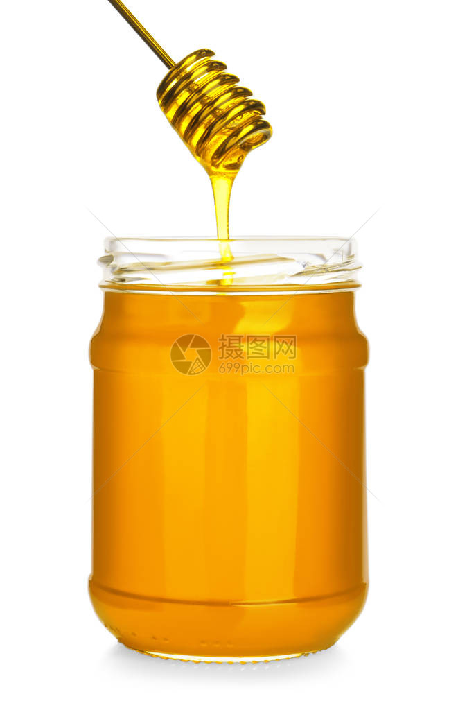 蜂蜜从勺子滴到白色隔离的罐子里图片