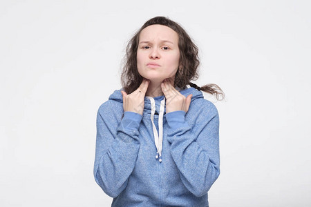 年轻的caucasian女子触摸痛苦的颈部图片