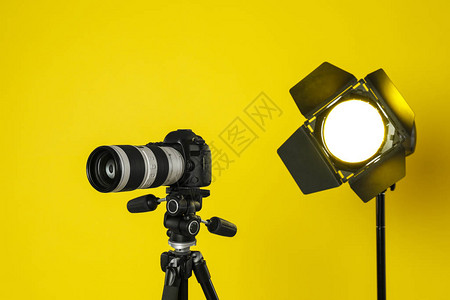 黄色背景的专业摄像专业录像摄机和照明图片