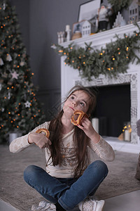 一头深色长发的漂亮女孩在一棵装饰精美的圣诞树上图片