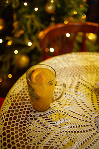 秋冬热茶配肉桂和橙子温暖的饮料和温暖的针织毛衣与肉桂和桔子的冬天茶以新年树为背景的茶图片