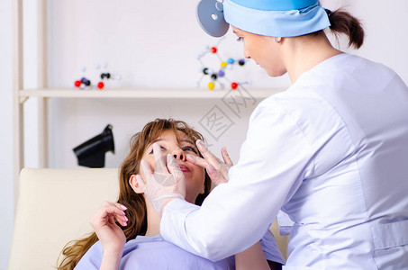 年轻女子拜访女医生耳鼻喉科医生图片