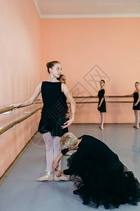 由一群美丽的年轻芭蕾舞者在古典芭蕾舞学校上课时表演舞图片
