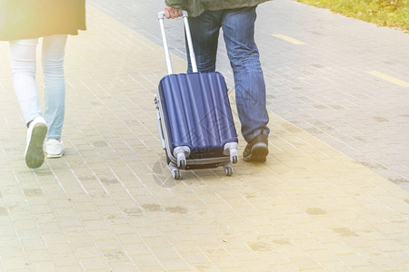 一男女携带手提箱在人行道上图片