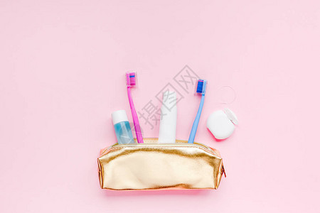 旅行化妆品钱包套件中的牙齿卫生和口腔牙科护理产品柔和的粉红色背景图片