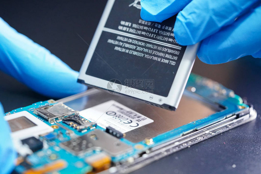 亚洲技术员修复智能手机电子技术微电路主板和电池图片