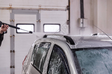 用高压水流从车顶去除肥皂泡沫的过程图片