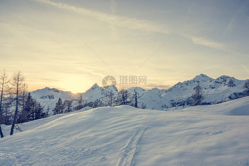 壮观的冬天山全景山在日落太阳在白雪皑的山脊和山峰后落山斯洛文图片