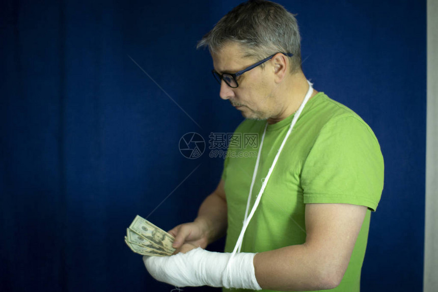 一个胳膊打石膏的男人从医院紧急医疗护理的费用和开支中算出钱来付了药费手术后图片