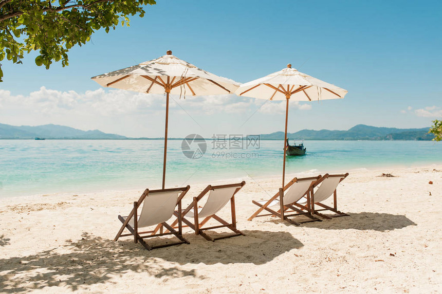 豪华度假海滩酒店的木制空椅子和雨伞在沙滩大海和蓝天上放松身心从海滩背景的海景为图片
