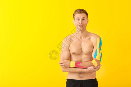 带有生理胶带的体育运动员在彩色背景图片