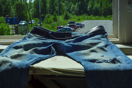 蓝色牛仔裤夏季日窗台上有潮湿图片