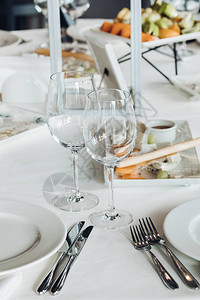 用空眼镜盘子和用具的白桌布遮住婚礼桌面图片