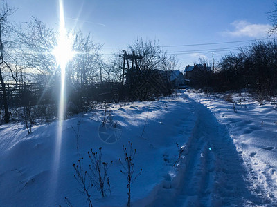 午后的阳光照亮了白雪皑的小路图片