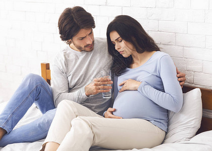 照顾丈夫的丈夫给他的怀孕妻子倒杯水图片