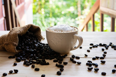卡布奇诺咖啡和咖啡豆在木质背景上早餐或咖图片