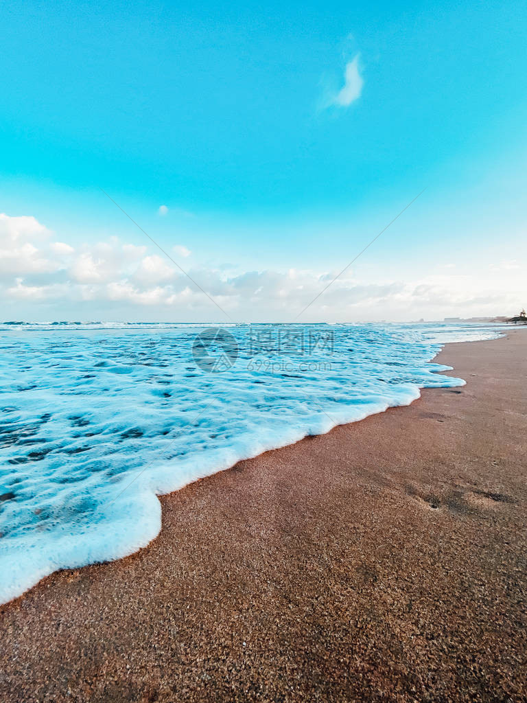 沙滩海水泡沫美丽的云彩在蓝天图片