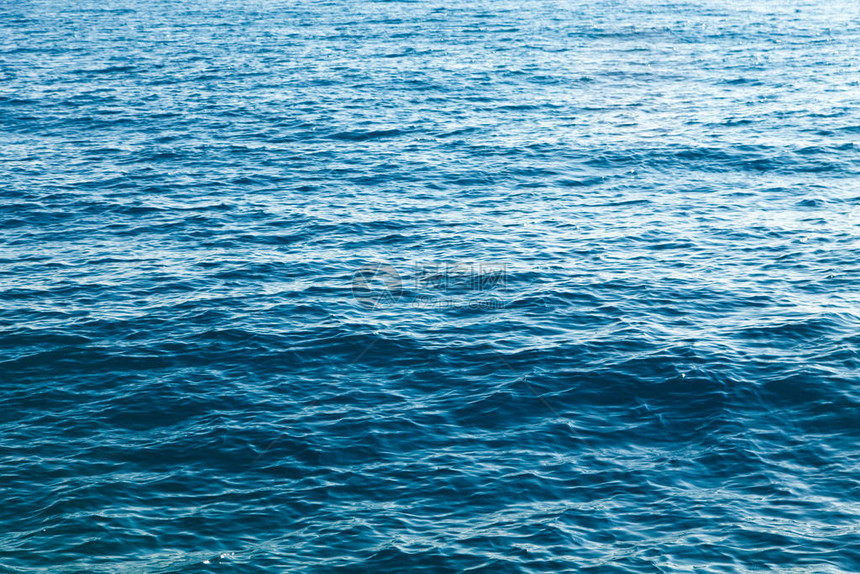 蓝色的清水纹理海洋和海的背景被太阳背光图片