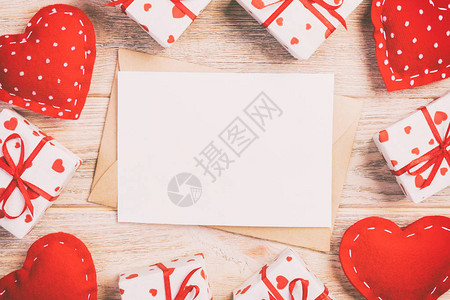 用红色的心和礼品盒在橙色木制背景的信封邮件情人节贺卡爱情或图片
