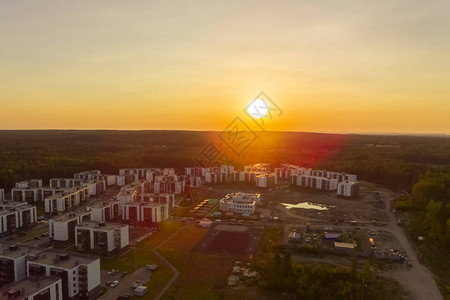 在俄罗斯日落时在城郊森林中的建筑图片