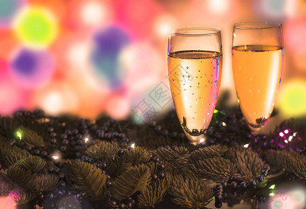 两杯香槟在模糊的彩色背景上配有新年图片