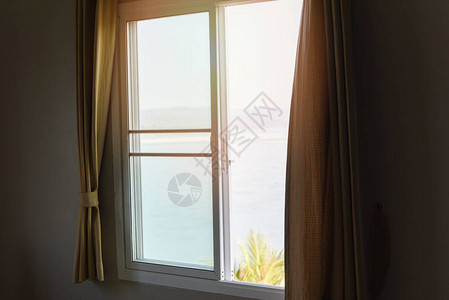 在卧室的清晨和阳光窗户玻璃中看到海边和山上图片