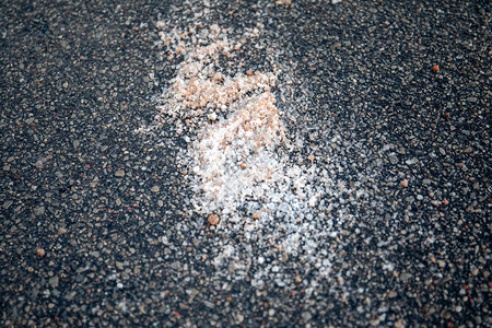 盐洒在人行道上冬季浮油和危险自然保图片